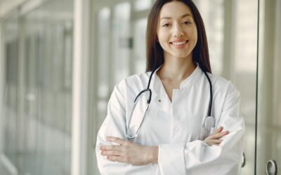 Medical student in white coat holding a stethoscope while studying for NEET